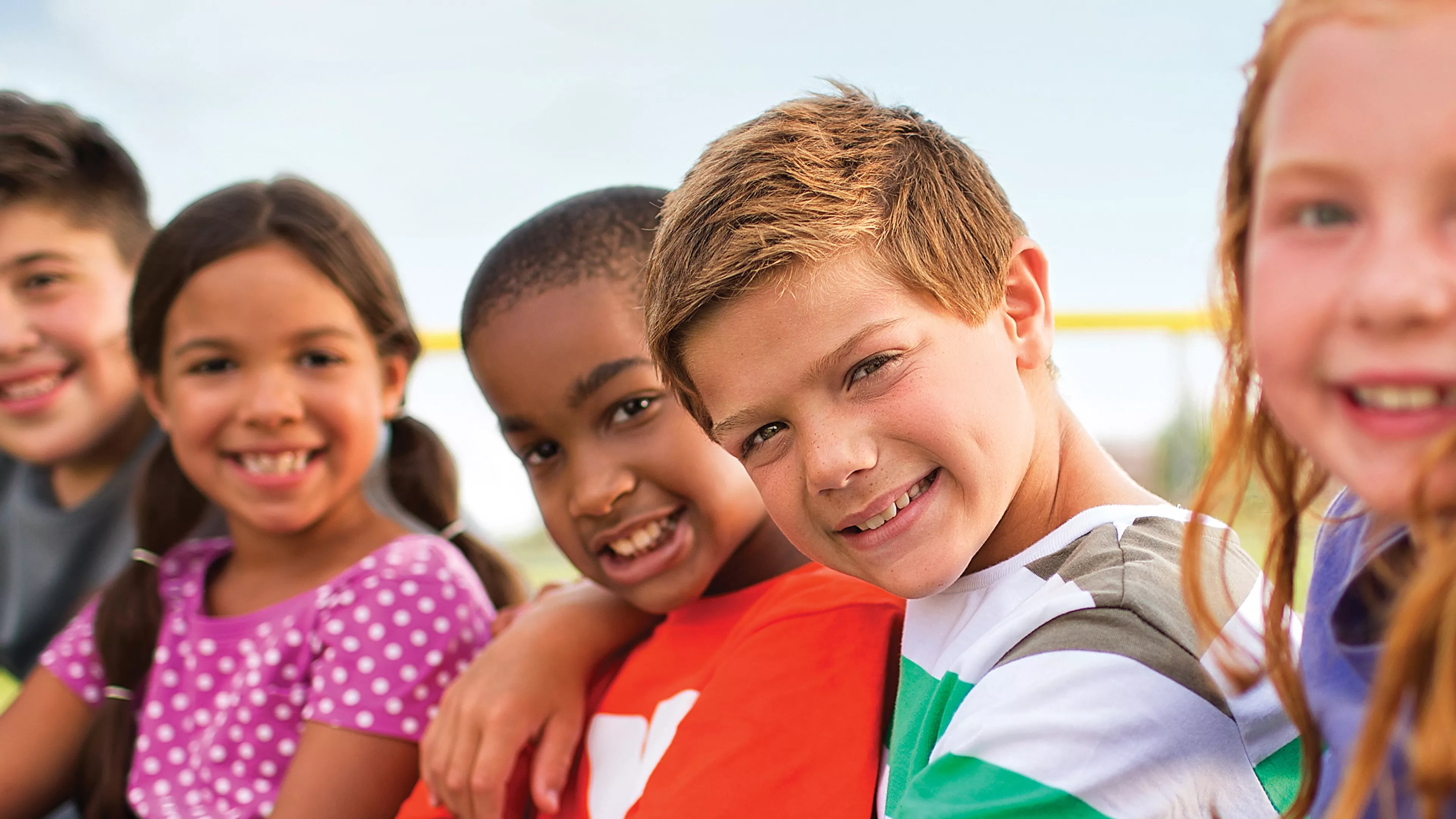 Kids sitting outside smiling