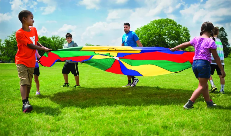 Kids and Camp Counselor play with a parachute
