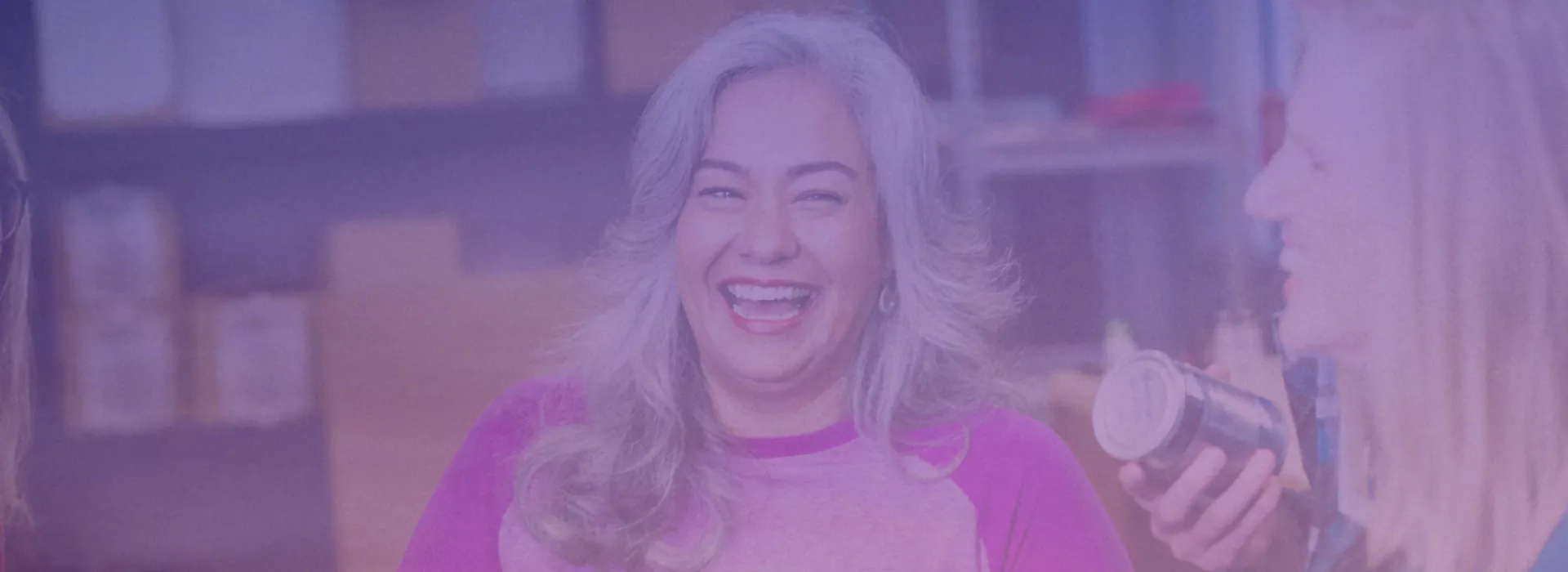 Person smiling with group of people holding cans